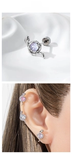 Vue macro et porté de boucles d'oreilles serpent en argent avec cristaux de zircon violets