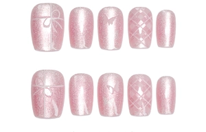 Detail of pink cat-eye press-on nails with white bow patterns and plaid nail art