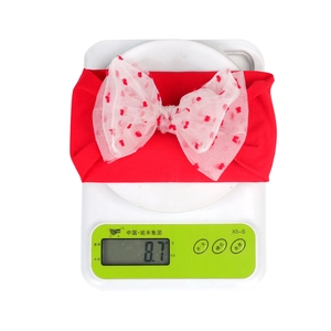 Close-up of lightweight baby nylon headband showing double-layered heart mesh bow on scale
