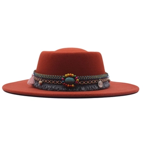 Detail of rust red wool felt boater hat featuring bohemian embroidered band and tassels