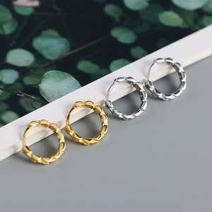 Detail of s925 silver geometric strap-style hoop earrings in gold and silver finishes