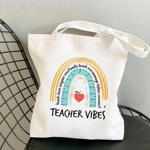 Detail of white cotton tote bag with colorful teacher vibes print on a mesh chair
