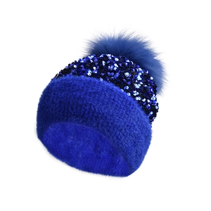Detail of navy blue knit beanie featuring sparkling sequins and a fluffy faux fur pom-pom