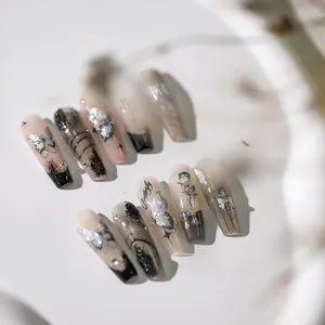 Makroaufnahme von Ballerina-Nägeln mit Laser-Schmetterlingen, Rosen und Strasssteinen