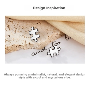 Macro view of S925 sterling silver puzzle stud earrings on elegant silk fabric