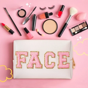 Flat lay of white PU leather makeup bag with pink chenille FACE letters and cosmetics