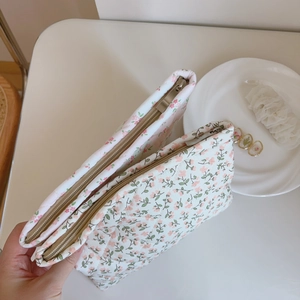 Close-up of pink floral quilted cotton cosmetic pouches with a secure metal zipper