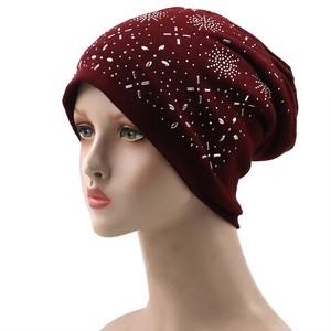 Detail of burgundy knit beanie featuring sparkling rhinestone star patterns on head model