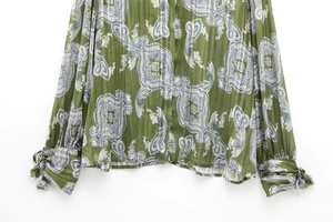 Detail of green paisley shirt showing striped texture and drawstring cuffs