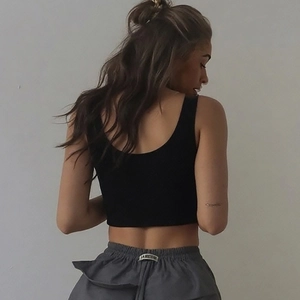 Ensemble de sport pour femme avec débardeur court noir et short gris, vue de dos