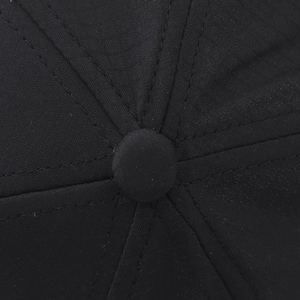 Macro detail of black baseball cap top button and reinforced six-panel stitching texture