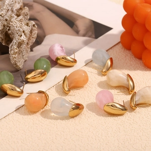 Close-up of colorful resin teardrop earrings on 18K gold base with aesthetic background