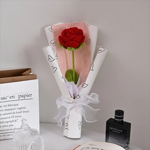 Detailed close-up of a handmade crochet red rose bouquet wrapped in heart pattern paper
