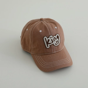 Detail of caramel brown kids baseball cap with white contrast stitching and KIGU embroidery
