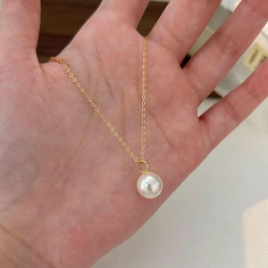 Elegant 925 sterling silver necklace featuring a single round white pearl on a gold chain