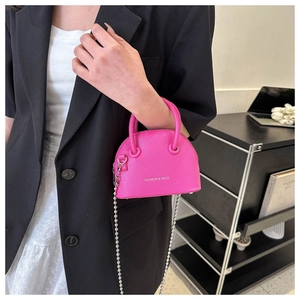 Detailed view of rose pink shell bag with silver bead chain strap and lychee pattern