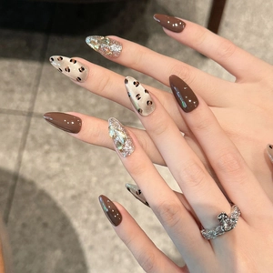 Unghie finte leopardate marroni a stiletto con accenti di pietre preziose brillanti