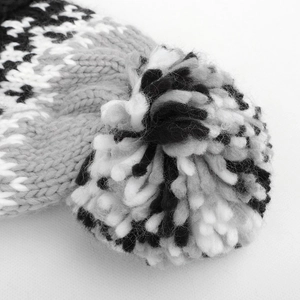 Close-up of the thick knit texture and soft faux fur pompom on the patterned beanie