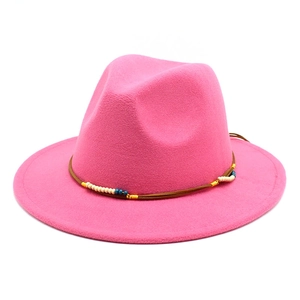 Dettaglio del cappello fedora rosa con fascia di perline etniche e tesa larga