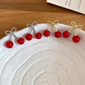 Elegant cherry bow earrings with red beads and twisted silver or gold accents