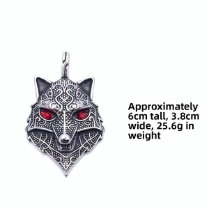Detail view of Viking wolf head pendant with red eye inlay and intricate Celtic patterns