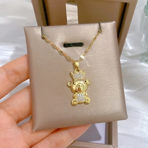 Close-up of luxury gold bear pendant with crown and white cubic zirconia crystals