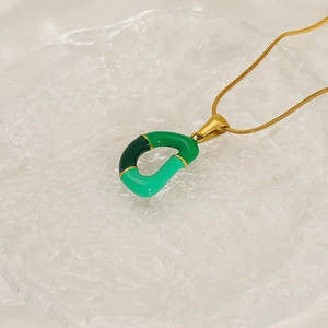 Collier en acier inoxydable doré avec pendentif lettre D en émail vert sur fond de glace