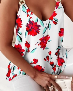 Detail of white floral top with gold ring straps and vivid red flower print patterns
