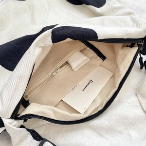 Detailed view of the corduroy cow print bag interior with zipper pocket and lining