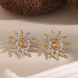 Macro detail of sunburst stud earrings in 18K gold and silver duo-tone finish