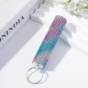 Close-up of three-section diamond-encrusted pill box keychain with colorful rhinestones