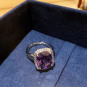 Detailed view of square purple zircon ring with silver adjustable band in a jewelry box