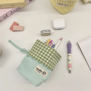 Detailed top view of mint green plaid stationery pouch with drawstring and cute dog label