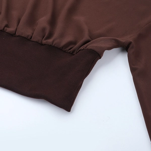 Nahaufnahme der gerippten Bündchen und feinen Stofftextur auf einem braunen Chiffon-Top