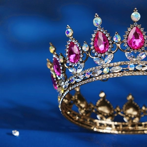 Detail of golden Baroque crown with pink teardrop gemstones and sparkling rhinestones