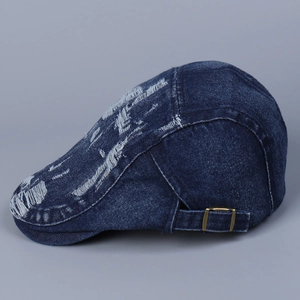 Side view of distressed dark blue denim flat cap with frayed holes and metal buckle