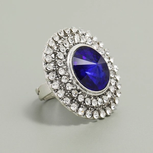 Detailed close-up of a large oval blue gemstone ring surrounded by sparkling rhinestones