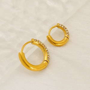 Polished 18K gold stainless steel hoop earrings with sparkling cubic zirconia on white fabric