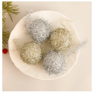 Detailed view of gold and silver wool thread Christmas balls with metallic texture on white tray