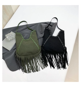 Detail of bohemian fringe shoulder bags with metal rivets and suede-like texture