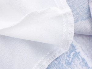 Gros plan détaillé des coutures d'ourlet et de la texture du tissu mousseline blanc