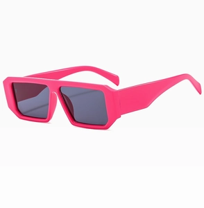 Detail view of pink rectangular sunglasses with wide temples and dark gray lenses