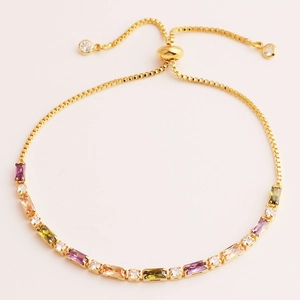 Detail of adjustable gold bracelet with colorful rectangular zircons and sliding clasp