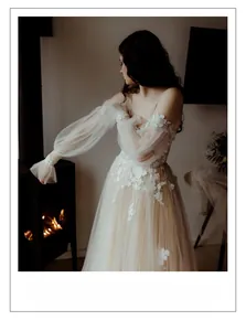 Detailed view of ivory floral lace appliques and airy puff sleeves on a vintage bridal gown