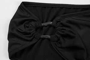 Detail of black stretch dress fabric with wavy metallic rings and pleated texture