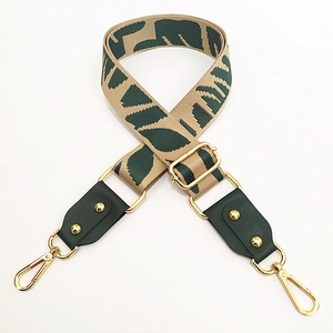Detail of green leather strap connector with gold metal clasp on jacquard webbing