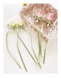 Close-up of artificial tulip hair clips with ribbons and pearls in pink and white