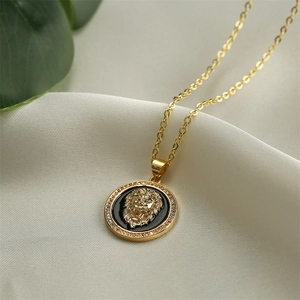 Detail eines Goldlöwen-Anhängers mit schwarzer Emaille und Zirkonia an einer Kette
