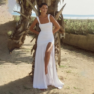 Detail of white square neck sleeveless dress with side slit and ruching on the beach