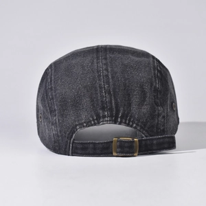Close-up of adjustable bronze metal buckle on washed black denim 5-panel outdoor cap